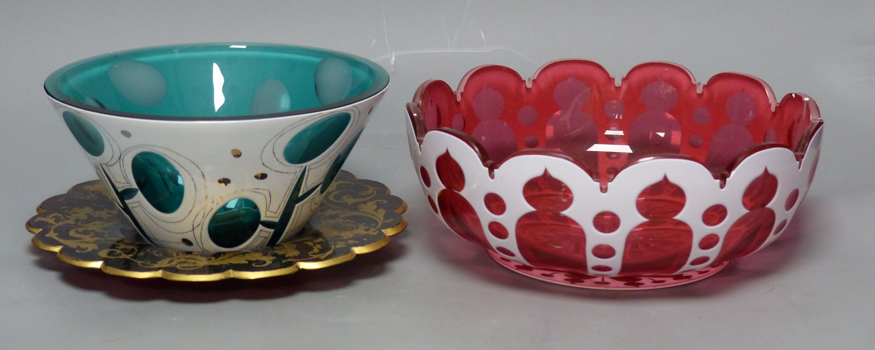 A Bohemian cranberry and white overlay glass circular bowl, a similar conical turquoise bowl and a gilded ruby glass dish